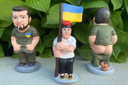 Una figura del caganer de Volodimir Zelenski y del caganer campesino con una bandera de Ucrania.