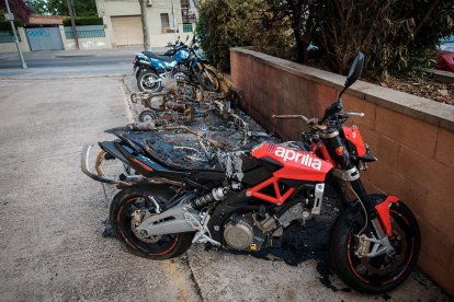 En primer terme una de les motos afectes parcialment i darrere les que han quedat calcinades.