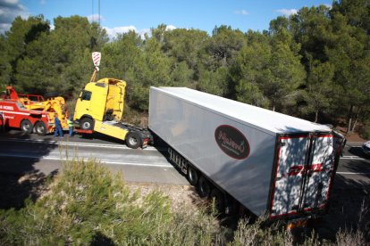 El camió accidentat pel vent en el moment en què la grua l'aconseguia aixecar per emportar-se la cabina.