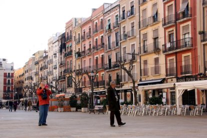 Un parell de turistes passejant i fent fotos amb el mòbil a la plaça de la Font de Tarragona, en una imatge del 14 de desembre del 2016