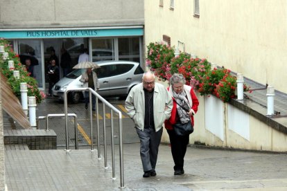 Una parella d'avis, pujant el pronunciat pendent del Pius Hospital de Valls, el 28 d'abril de 2016