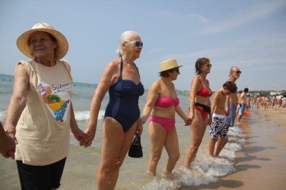 Un centenar de vecinos se unen en una cadena humana para reclamar más protección por la Platja Llarga