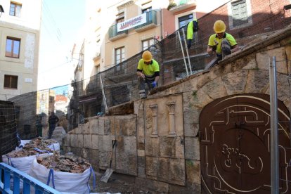 Els operaris treballen en l'enderroc del mur.