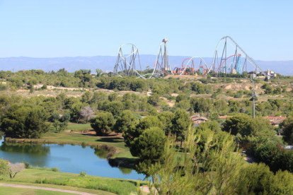 Terrenos del Centro Recreativo y Turístico (CRT) de Vila-seca y Salou, con un lago y campo de golf de PortAventura (Lumine) en primer término, y las atracciones al fondo.