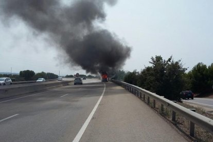 Imatge del cotxe cremant sobre la grua que l'havia recollit.