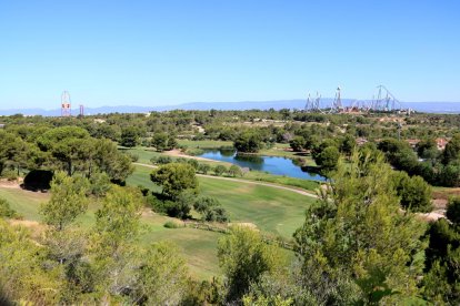 Panoràmica dels terrenys on s'ha projectat el Centre Recreatiu i Turístic (CRT) de Vila-seca i Salou, amb el parc temàtic PortAventura, de fons, en una imatge del juliol del 2017