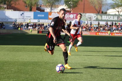 Jorge Miramón condueix la pilota durant un instant de l'enfrontament d'aquest diumenge, sota la mirada d'un oponent de l'Osca.