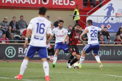 El roig-i-negre Vítor Silva, al centre de la imatge, mira de desfer-se de Pombo, del Saragossa, en un instant del partit de diumenge.