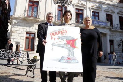 El director artístic del Trapezi, Leandro Mendoza, sostenint el cartell de la 21a edició amb el director dels serveis territorials de Cultura, Jordi Agràs, i la regidora de Cultura de Reus, Montserrat Caelles.