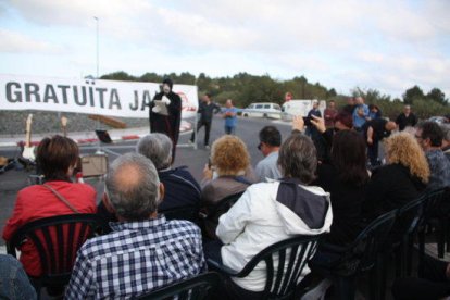 Manifestants asseguts en cadires, enmig de l'N-340, escoltant el personatge de la mort.