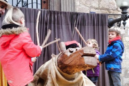 Niños y niñas haciendo cagar el Tió de Montblanc la pasada Navidad.