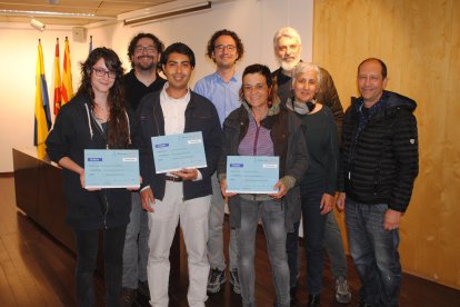 Fotografía de familia del acto de entrega de los premios, con los tres ganadores.