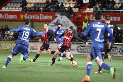 Campins, en el centro, en una acción durante el CF Reus-Getafe, bajo la mirada de Jorge Miramón.