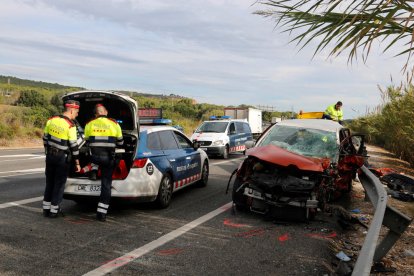 El cotxe de la víctima mortal de l'accident a l'N-340 a Tarragona al costat de dos agents dels Mossos.