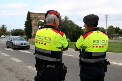 Pla mig de dos agents dels Mossos d'Esquadra en el control informatiu a l'Arc de Berà.