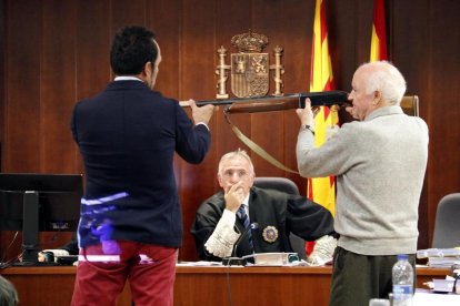 L'acusat agafa l'escopeta amb què va matar la víctima, durant el tercer dia de judici, amb un pèrit de la defensa i el president de la Sala al centre.