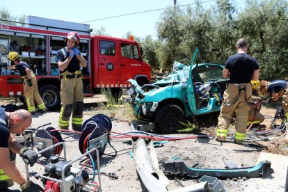 Pla obert de diversos Bombers al costat del vehicle accidentat a la T-302 a Cambrils. Imatge del 14 de juny del 2017