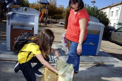 Imagen de archivo de una educadora comprobando el reciclaje de una vecina.