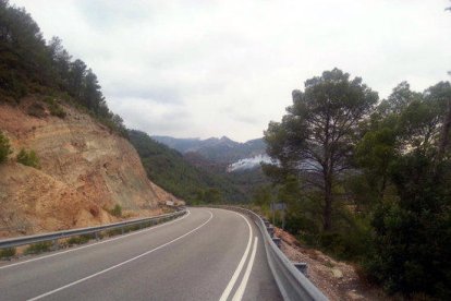 Pla general amb les flames i la columna del fum al fons, prop de la carena de la muntanya, de l'incendi provocat per un llamp a Paüls.