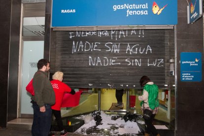 Moment en què empleats l'oficina de Gas Natural obren la persiana durant l'acció reivindicativa de la PAH, ahir a la tarda.