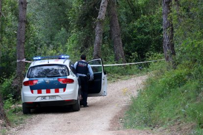 Un cotxe dels Mossos al camí on es va trobar el cos calcinat.