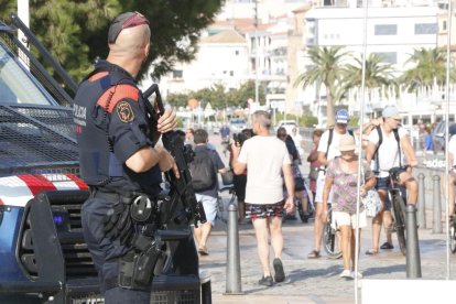 Pla americà d'un agent dels Mossos d'Esquadra armat vigilant a quarts de deu del matí d'aquest divendres, al passeig marítim de Cambrils. Imatge del 18 d'agost de 2017 (horitzontal)