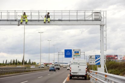 Dos operarios instalando el nuevo radar por tramo que ha entrado en funcionamiento este año en Tarragona.