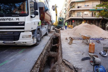 Un camión y una excavadora trabajan en el lugar donde se ha hecho una zanja para cambiar las cañerías.