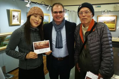 Dos admiradors japonesos mostrant una dedicatòria de Jordi Isern, al centre.