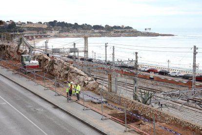 Uns operaris treballan en el terreny on es farà la cimentació de les columnes que soportaran la passarel·la.