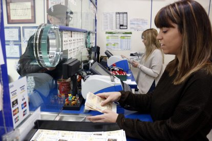 Dues venedores de loteria a l'administració número 1 de Mollerussa despatxant dècims de la Grossa de Nadal.