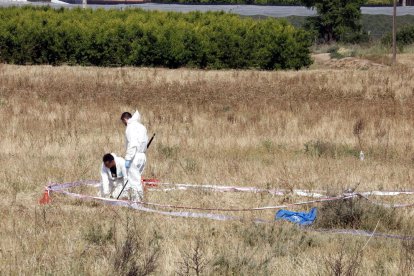 Primer pla de Mossos d'investigació analitzant el lloc dels fets, a la Bordeta.