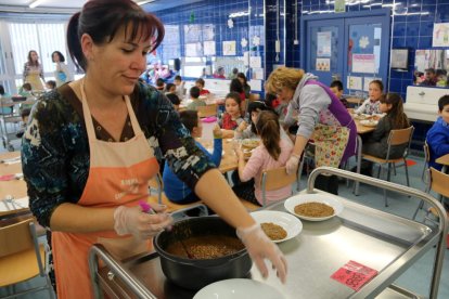 Una de las madres que dan apoyo diariamente a las monitoras del comedor de la Escola Consol Ferré, preparando los platos.