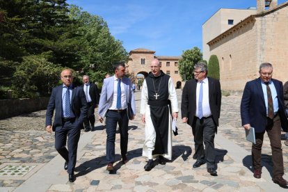 El conseller de Cultura, Santi Vila, amb l'abat de Poblet, Octavi Vilà, i el director de l'Arxiu Nacional de Catalunya, Francesc Balada, entre altres autoritats, caminant per l'exterior del Monestir de Poblet.