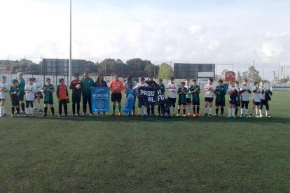 Els jugdors dels dos equips, mostrant la pancarta antiviolència.