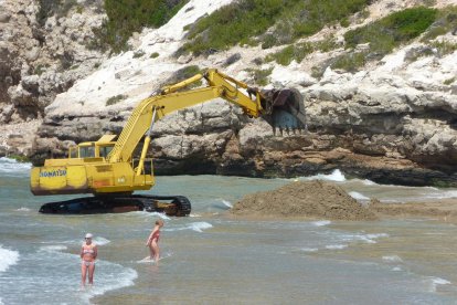 La màquina duent a terme els treballs de reposició de sorra de la platja Llarga.