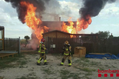 Imagen de los bomberos trabajando en la extinción del fuego que ha quemado una casa de madera en Reus.