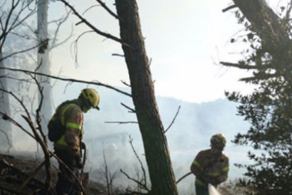 Dos bomberos apagando uno de los fuegos de Alforja.