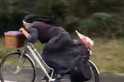 La moja sobre la bicicleta, amb els hàbitsi en posició aerodinàmica.