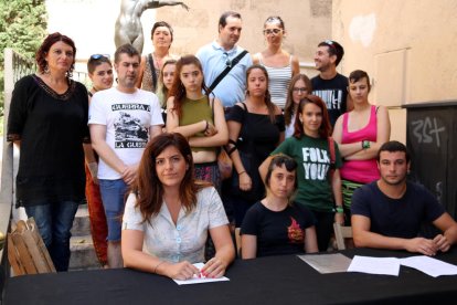 Foto de grup de regidors i simpatitzants de la CUP de Reus a les escales de les Peixateries Velles, en una roda de premsa per denunciar un suposat cas de violència masclista i qüestionar l'actuació policial. Imatge del 26 de juliol del 2017