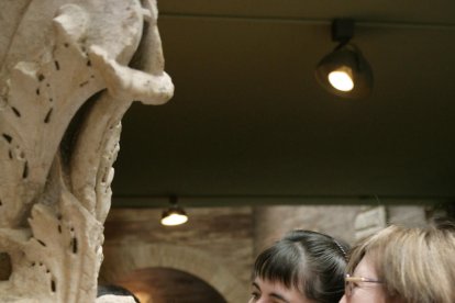 Un voluntari acompanyant a una invident en una visita a un museu.