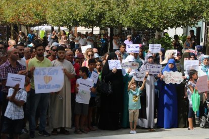 Pla obert de diversos manifestants musulmans a Valls, amb pancartes, en la concentració a Valls. Imatge del 26 d'agost de 2017