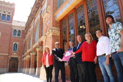 Foto de familia de los impulsores del Festival de las Artes de Reus, delante del pabellón de los Distinguidos del Instituto Pere Mata donde tendrá lugar la primera edición de este festival de verano, con un cartel promocional, el 31 de mayo del 2017.