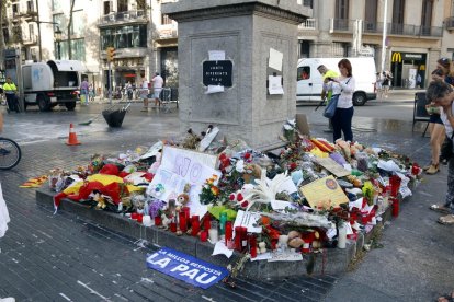 El pedestal de la columna del capdamunt de la Rambla amb flors i cartells de record.