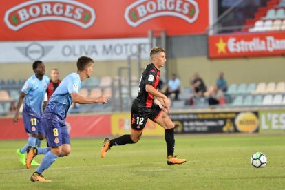 El lateral Joan Campins conduce la pelota en el partido de presentación de los rojinegros contra el Girona.