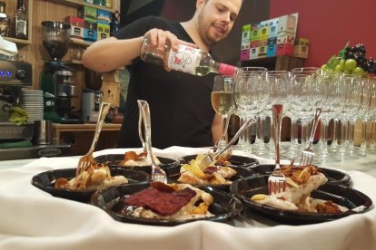 Un restaurador sirviendo copas de vino durante la ruta de tapas.