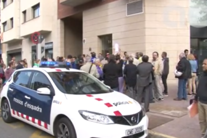 Imagen de la concentración que medio centenar de personas llevan a cabo en las puertas del domicilio particular de Jordi Ignasi Sànchez, jefe de gabinete de la consellerIa de Gobernación.