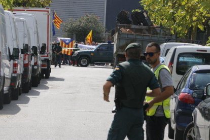 Agentes de la Guardia Civil, con manifestantes en el fondo, en la nave de Bigues i Riells donde han encontrado papeletas del 1-O. Imagen del 20 de septiembre del 2017