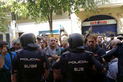 La policía española envolviendo la sede de la CUP, mientras simpatizantes gritan en contra de la actuación y en favor del 1-O.