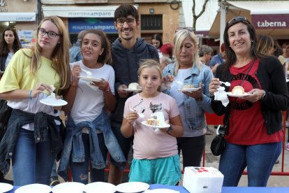 Un grup d'amics saboreja el pastís, que media 75 metres de llargada.